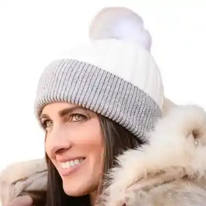 A cozy two-toned knit beanie with a soft white pom-pom on top.